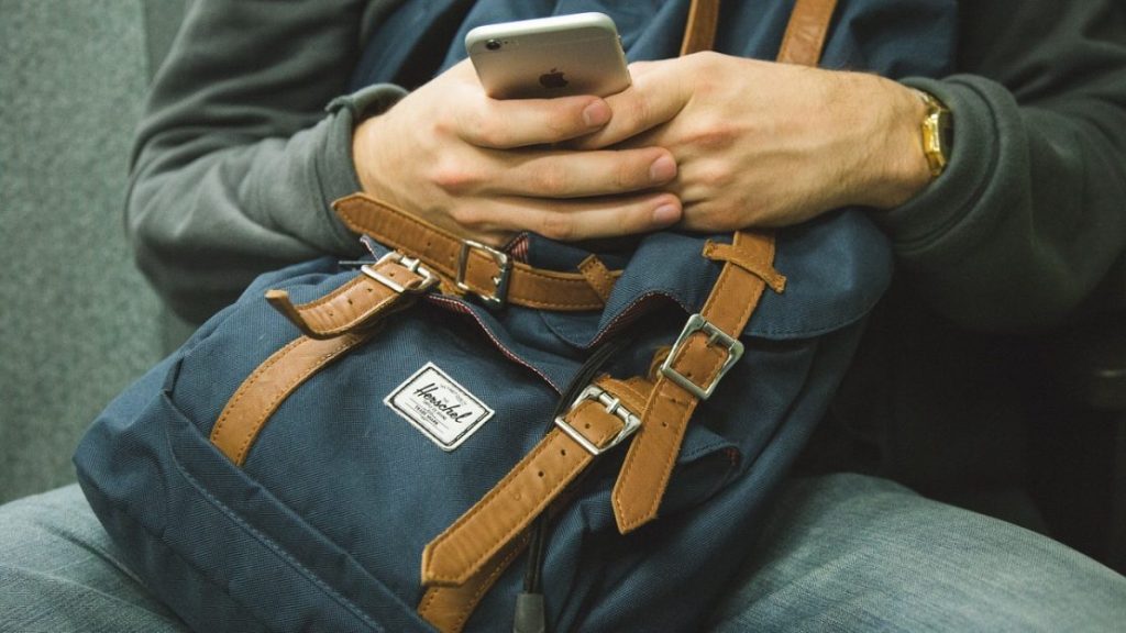 Man Holding Phone Over A Bag