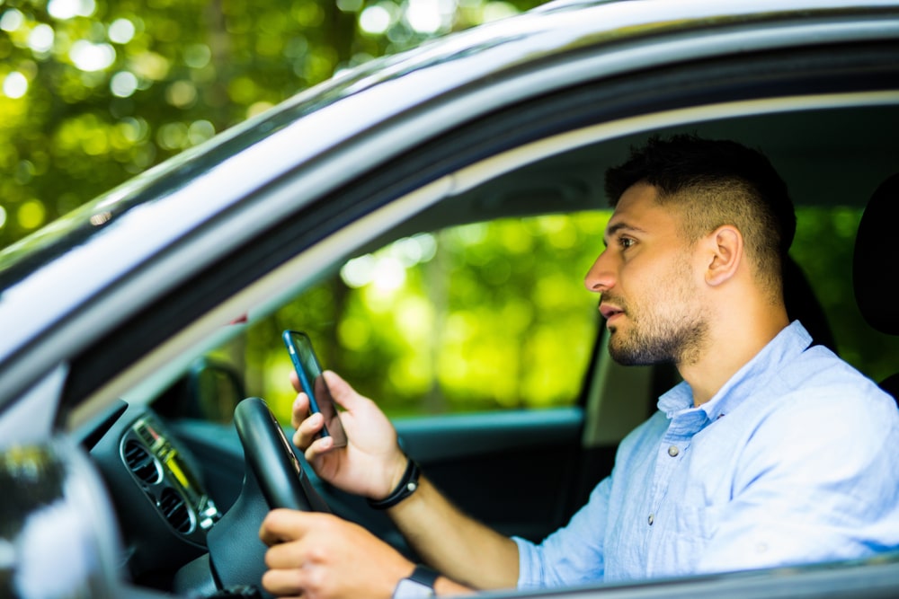 Man Driving And Checking His Phone